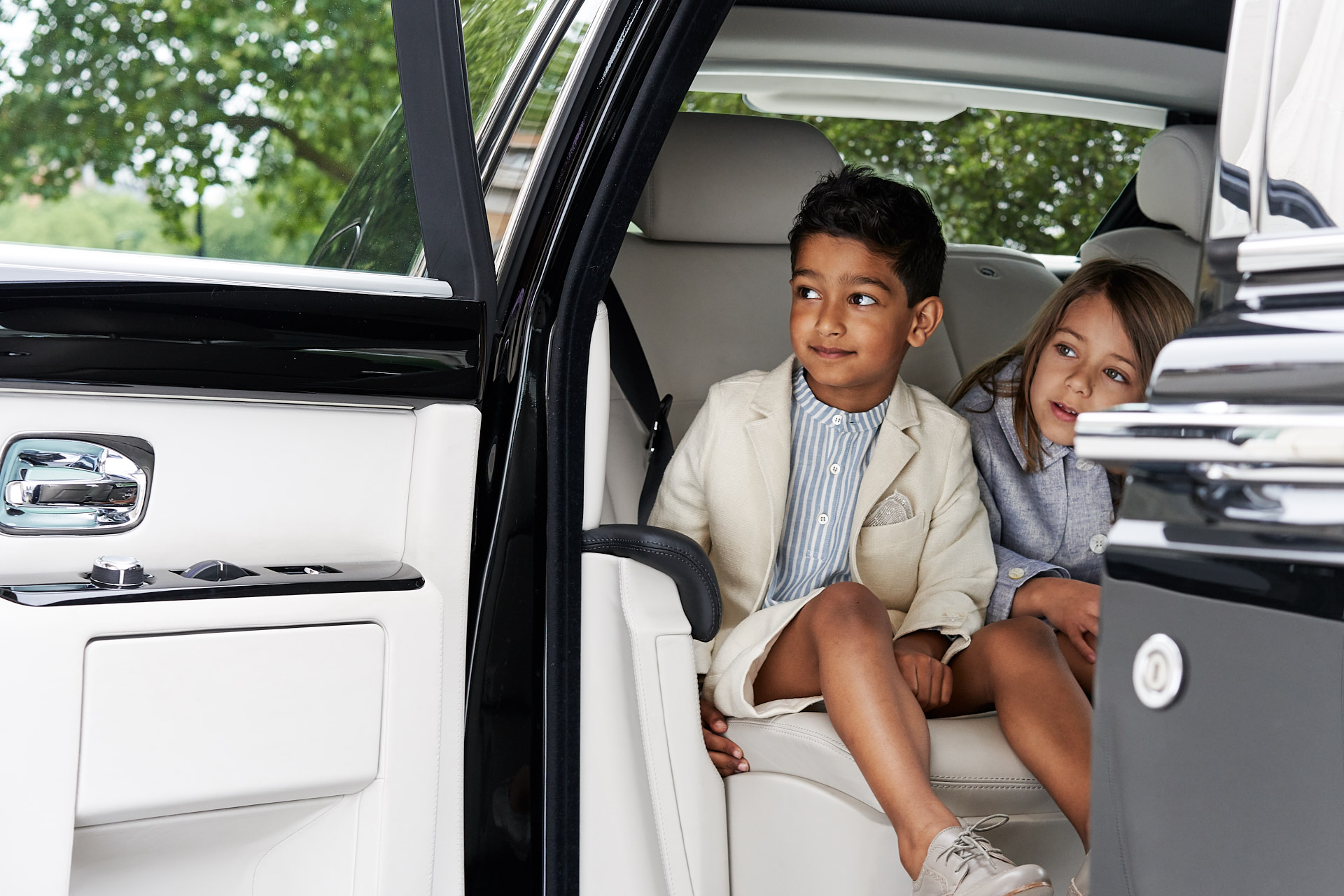 Children arriving in a chauffeur driven rolls royce at The Lanesborough